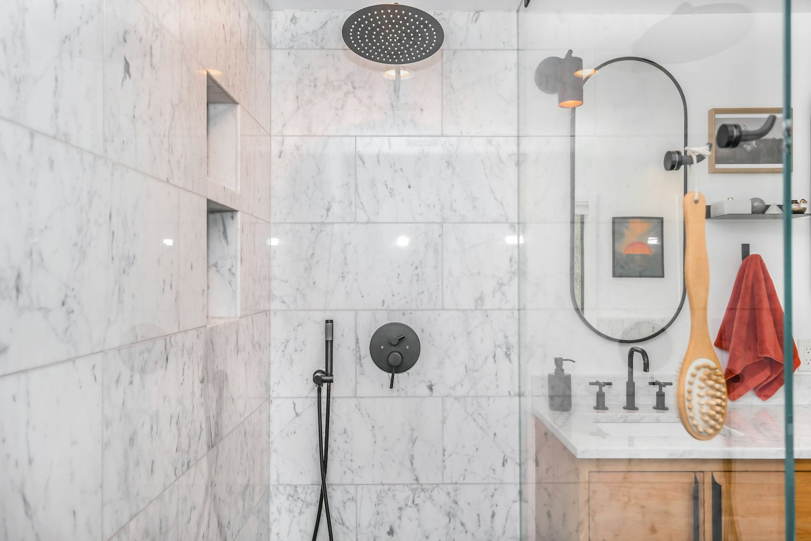 Finished walk-in shower with marble tile and matte black fixtures