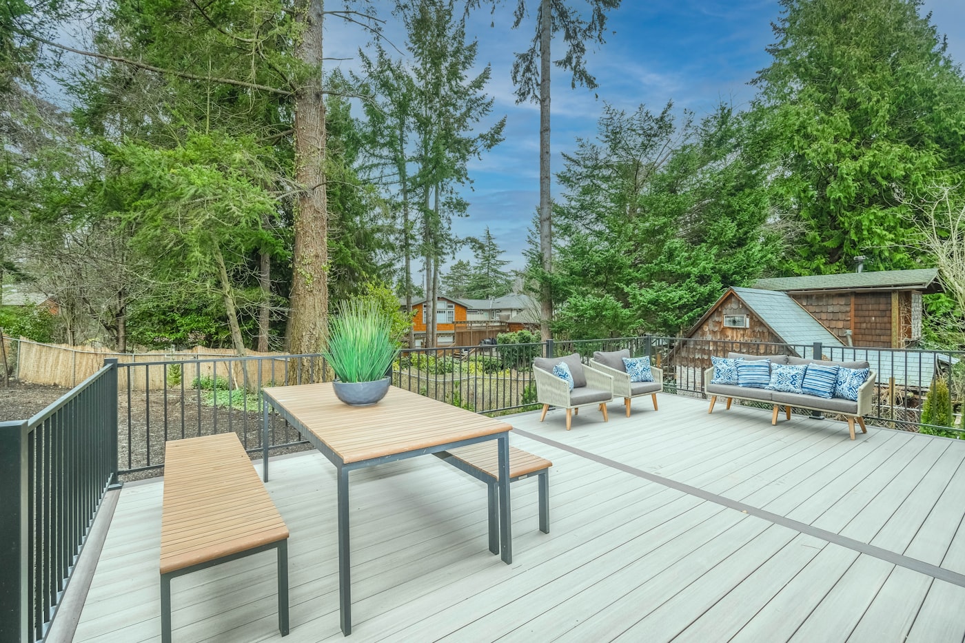 Composite deck with outdoor seating and dining area surrounded by trees